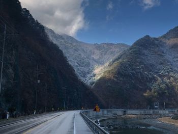 Road by mountain against sky