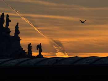 Silhouette statue against sky during sunset