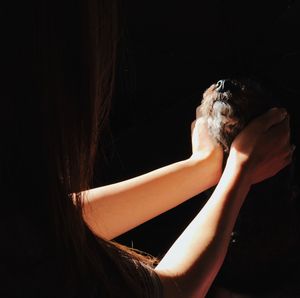 Close-up of woman hand against black background