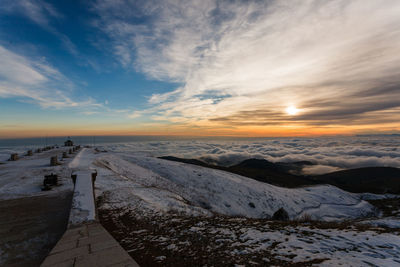 Scenic view of snowcapped mountains against sky during sunset