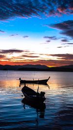 Boat moored on sea against sky during sunset