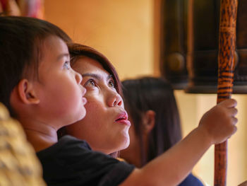 Close-up of woman with son holding pole