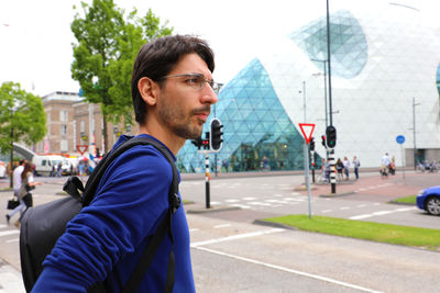 Young man looking away in city