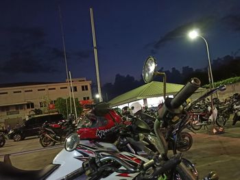 Bicycles parked on street against sky at night