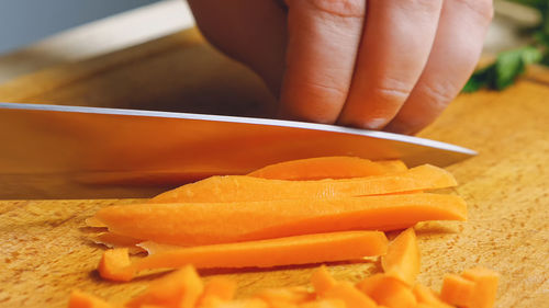 Close-up of cutting carrots with a knife on a cutting board. preparation of ingredients.
