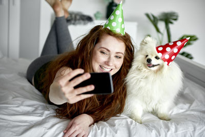 Portrait of young woman using laptop on bed at home