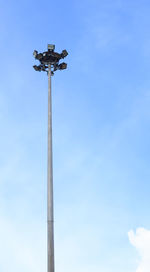 Low angle view of weather vane against blue sky