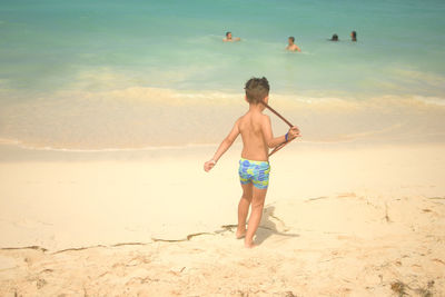 Full length of shirtless man on beach