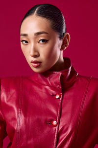 Portrait of young woman against yellow background