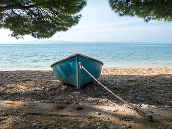Deck chairs on beach against sky