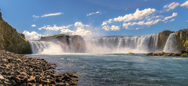 Scenic view of waterfall against sky