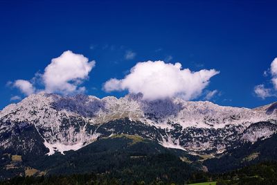 Scenic view of mountains against blue sky