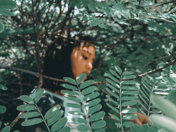 Close-up of woman amidst plants