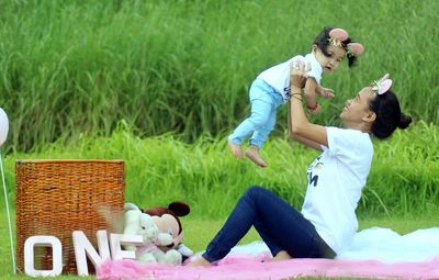 Mother and daughter sitting on grass