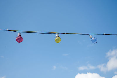 Low angle view of hanging flags against clear blue sky