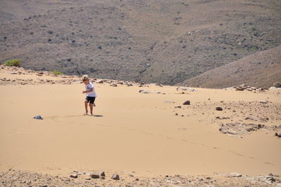 Boy walking at desert