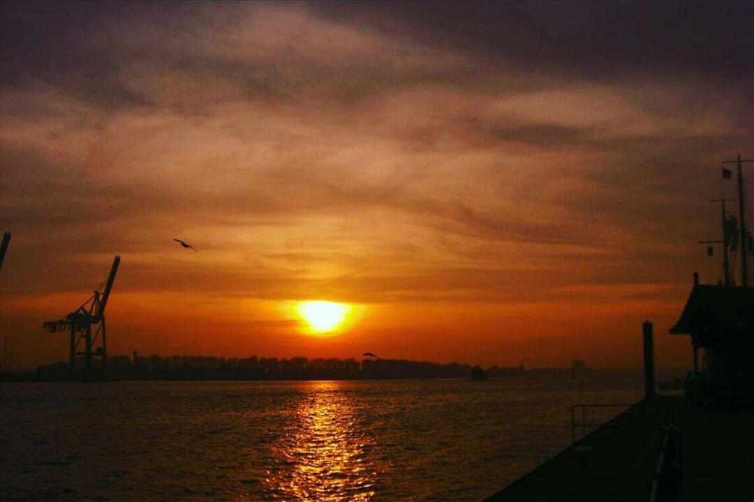 sunset, orange color, water, silhouette, sky, nature, beauty in nature, sun, scenics, tranquil scene, sea, tranquility, nautical vessel, outdoors, reflection, cloud - sky, waterfront, no people, windmill