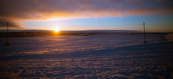 Scenic view of snowy landscape against sky during sunset