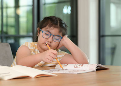 Young woman writing in book at home