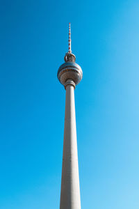 Low angle view of communications tower against blue sky