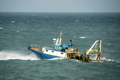 Boat sailing in sea against sky