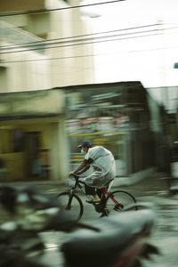 Man riding bicycle on street in city