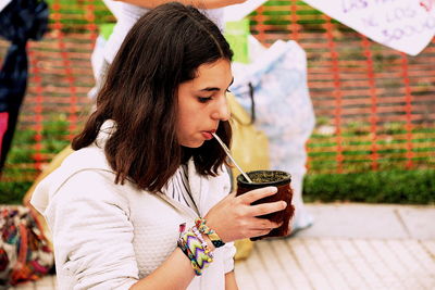 Young woman drinking water from coffee