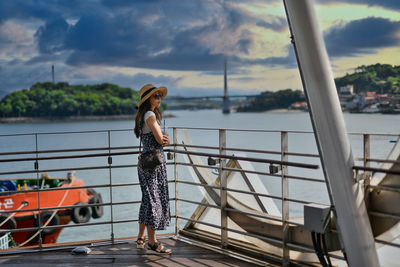 Rear view of woman standing in boat