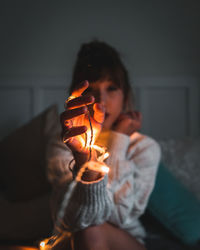 Midsection of woman holding light at home