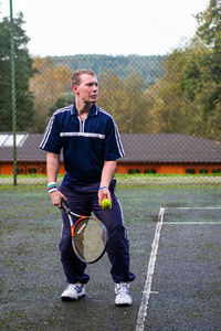 Full length of man holding ball while standing in park