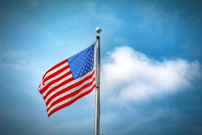 Low angle view of american flag against blue sky