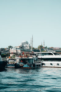 Boats in sea against clear sky