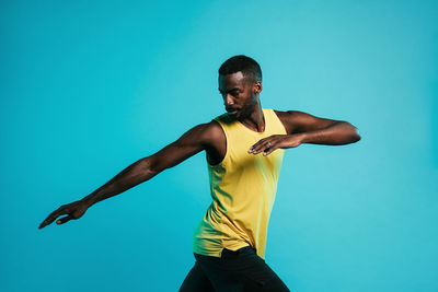 Full length of man standing against blue background