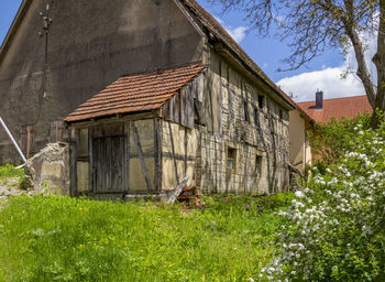 Exterior of old house on field against sky