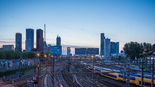 Railroad tracks amidst buildings in city against sky
