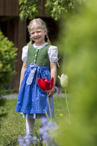 Portrait of cute smiling girl standing at public park