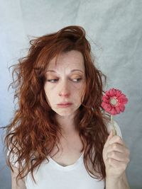 Portrait of smiling young woman holding yellow flower