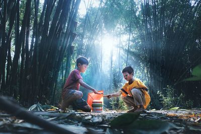 Indonesian children play kite under a tree