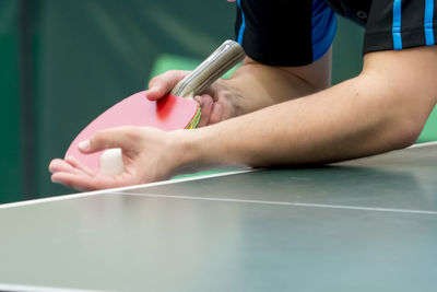 Midsection of man playing table tennis