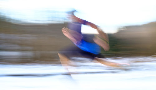 Blurred motion of man surfing in water