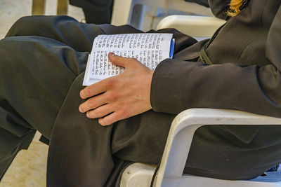 Midsection of man sitting on seat in train