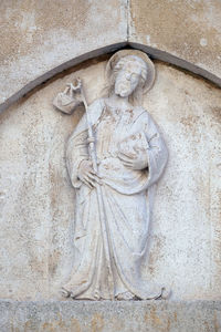 Low angle view of angel statue against wall