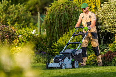 Full length of gardener gardening at yard