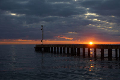 Silhouette pier on sea against sky during sunset