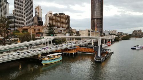 Bridge over river in city against sky