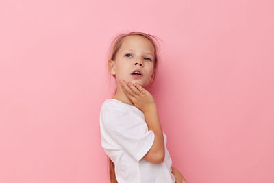 Portrait of cute girl against pink background