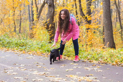 Full length of woman with dog during autumn