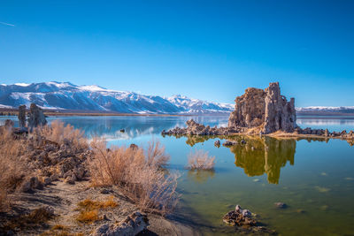 Scenic view of lake and mountains against blue sky