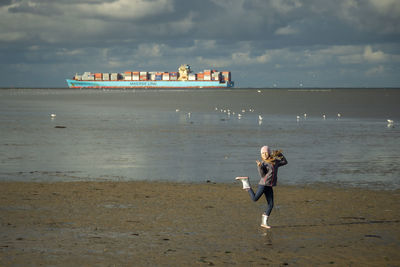 Man and woman on beach against sky