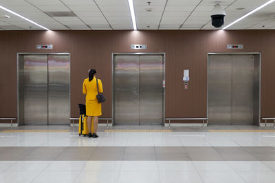 Rear view of people walking in corridor of building